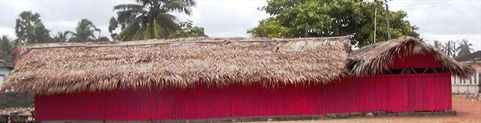 Bamboo building painted red with a thatch roof