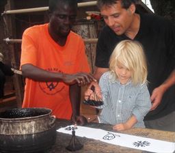 Young girl stamping Adinkra cloth