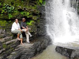 Couple sitting next to Akaa Falls in Ghana