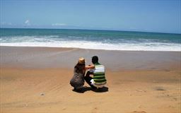 Black and whith couple facing ocean