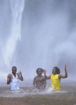 Three men standing in waterfalls in Ghana