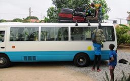 Loading luggage to roof of Coaster