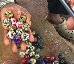 freshly polished glass beads in hand