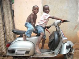 Young boys having on parked scooter